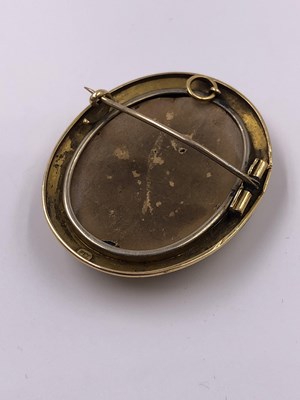 Lot 1035 - A porcelain and gold portrait brooch,...