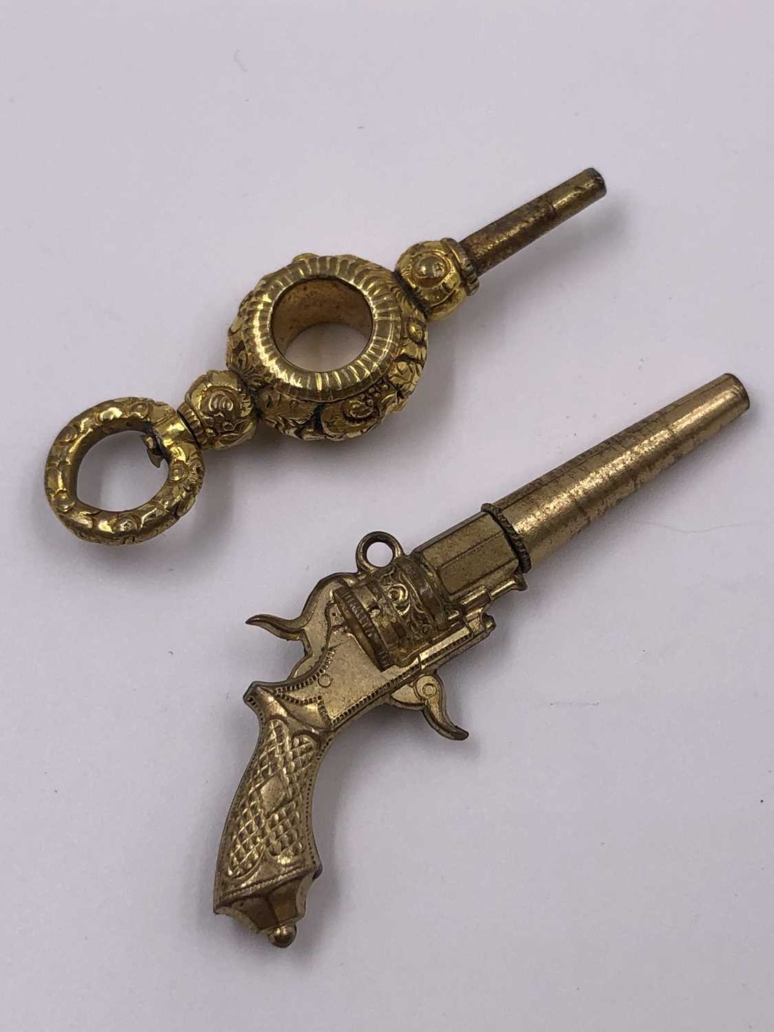Lot 1017 - An antique miniature pistol clock key and one...