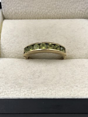 Lot 1015 - A 9ct hallmarked gold peridot channel set half...