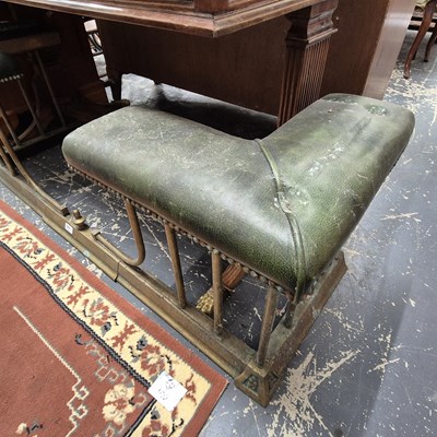 Lot 2246 - An antique leather-topped brass club fender....