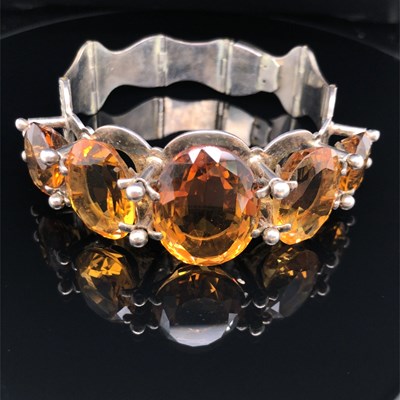 Lot 19 - A Scottish-style gemset bangle. A hinged...