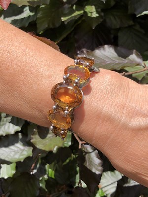 Lot 19 - A Scottish-style gemset bangle. A hinged...