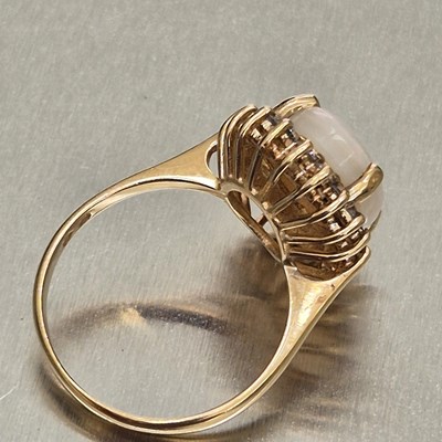 Lot 45 - An opal and diamond oval cluster ring. The...