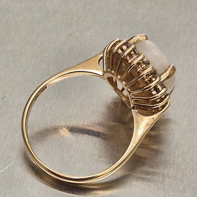 Lot 45 - An opal and diamond oval cluster ring. The...