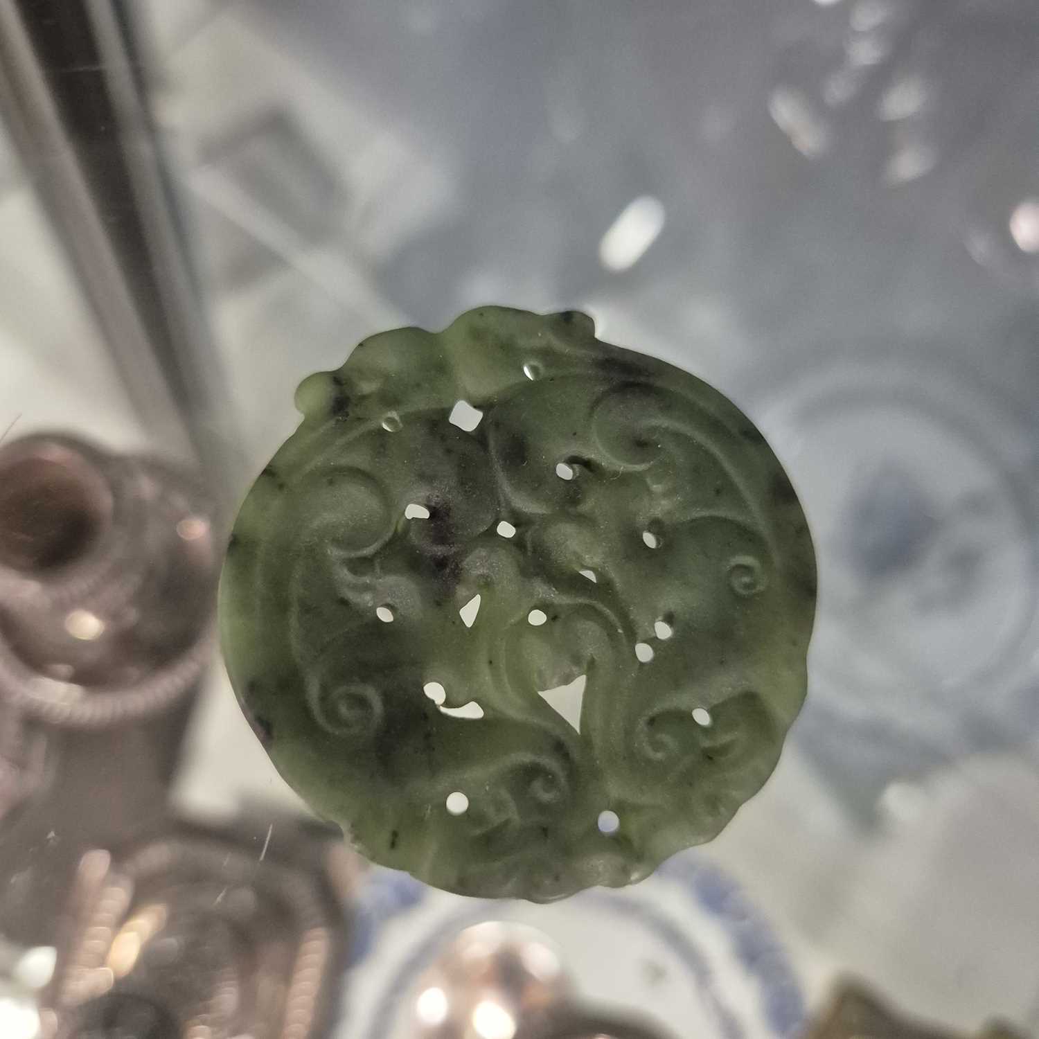 Lot 247 - Three Chinese pierced roundel pendants in jade...