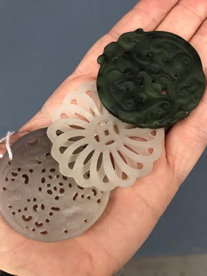 Lot 247 - Three Chinese pierced roundel pendants in jade...