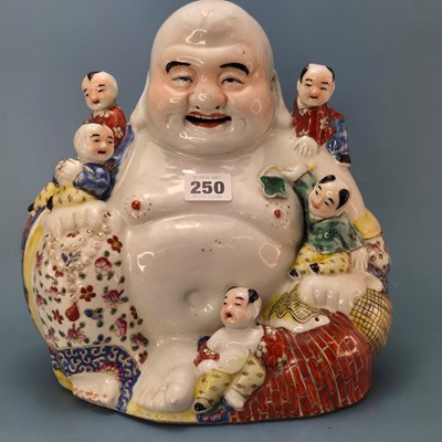 Lot 250 - A Chinese porcelain figure of Budai seated by...