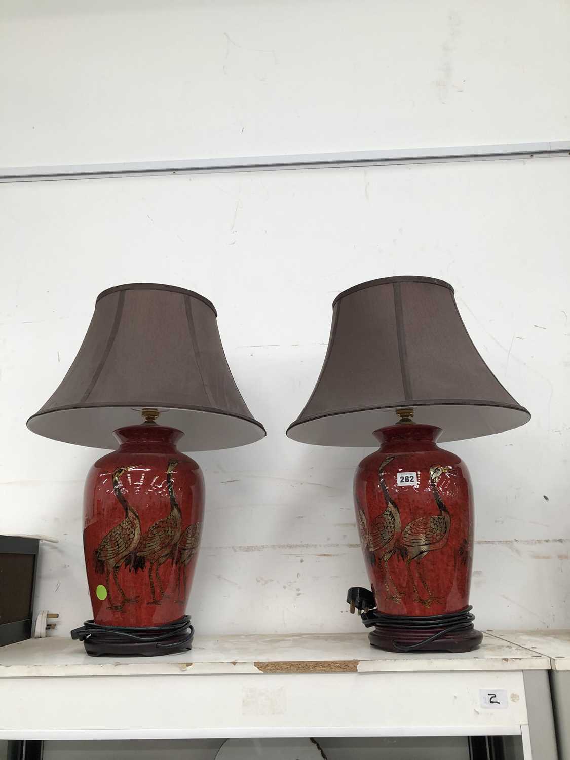 Lot 282 - A pair of red glazed table lamps.