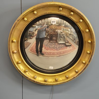 Lot 277 - A Regency convex mirror within a reeded ebony...