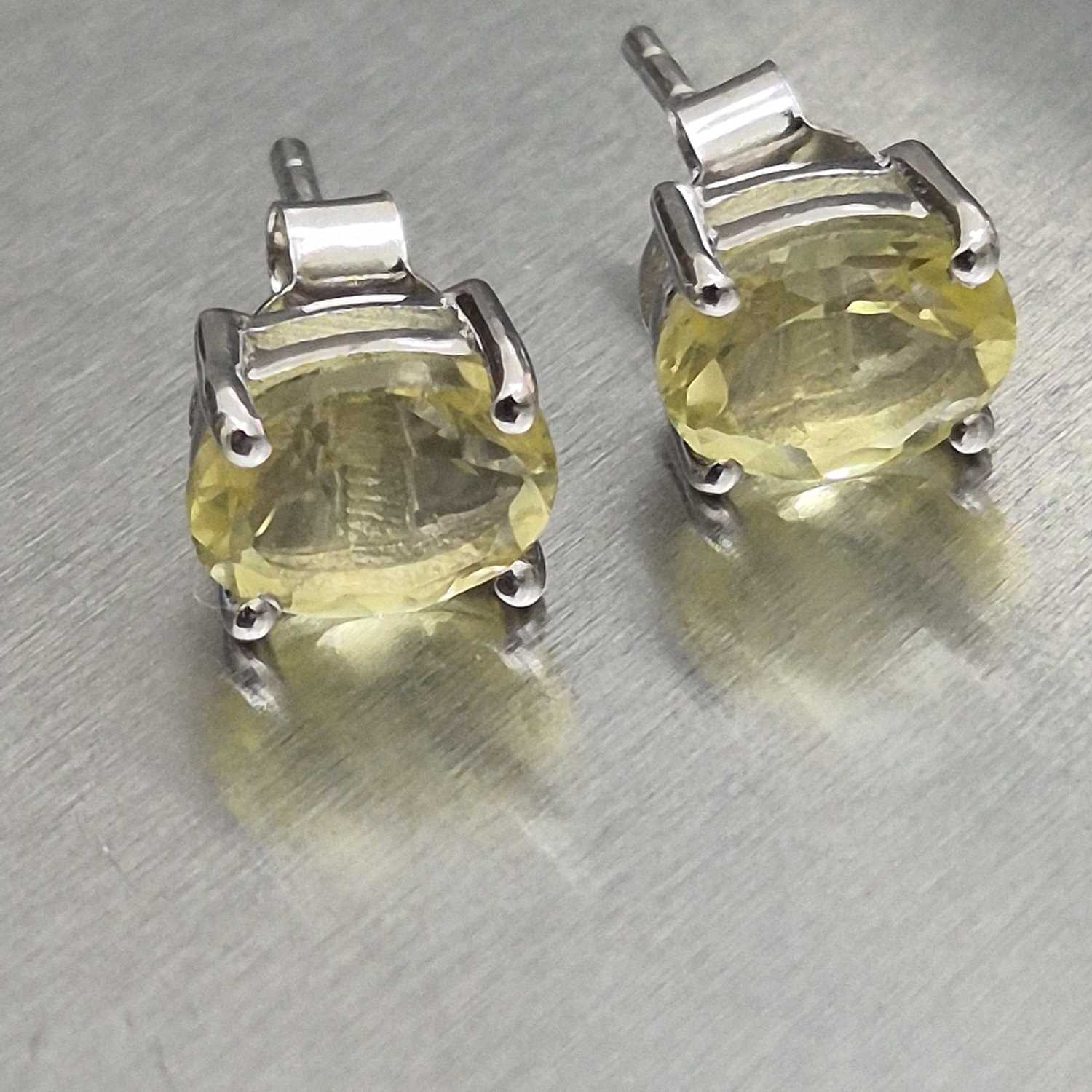 Lot 25 - A pair of lemon quartz stud earrings set in...