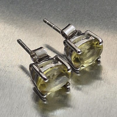 Lot 25 - A pair of lemon quartz stud earrings set in...