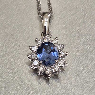 Lot 61 - A sapphire and diamond oval cluster pendant...