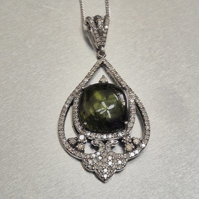 Lot 78 - A tourmaline and diamond pendant. The central...