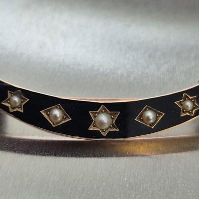Lot 76 - An antique seed pearl and black enamel...