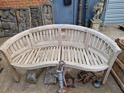 Lot 705 - A teak curved garden bench (banana bench).
