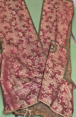 Lot 289 - A red ground damask hanging with a winged head...