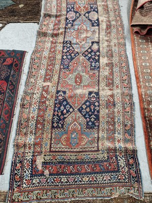 Lot 650 - An antique Caucasian tribal runner. 295 x 98cms