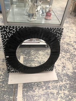 Lot 620 - A circular mirror in a black sunburst frame...