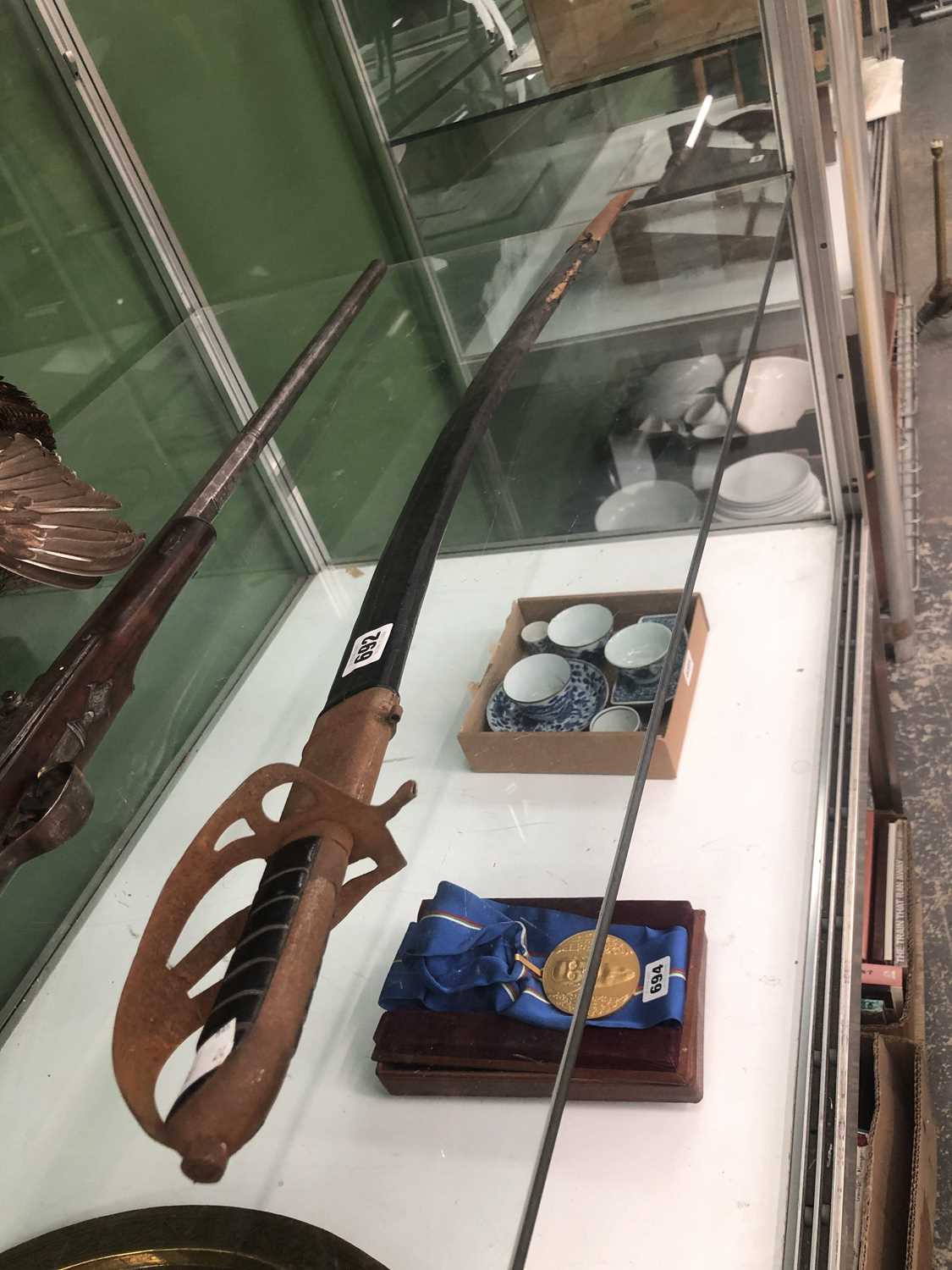 Lot 692 - A sabre in a leather scabbard, the blade etched
