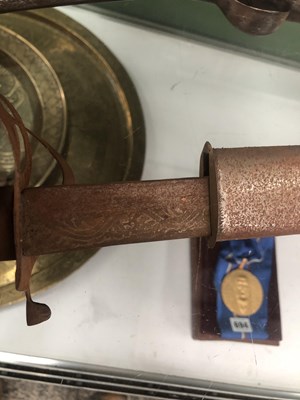 Lot 692 - A sabre in a leather scabbard, the blade etched