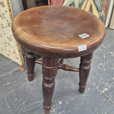 Lot 1101 - An oak stool with a circular seat and four legs