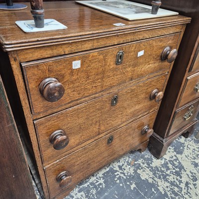 Lot 1124 - An oak small chest of three graded long...