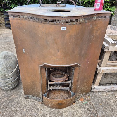 Lot 748 - An antique copper clad stove / room heater.