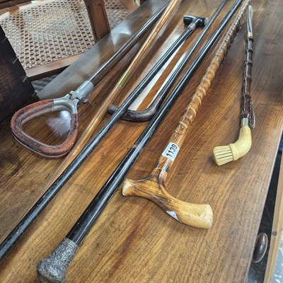 Lot 1139 - A silver topped walking cane, three walking...