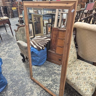 Lot 1141 - A bevelled glass rectangular mirror in a pine...