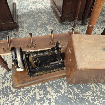 Lot 1058 - A sewing machine  and a coat rack.