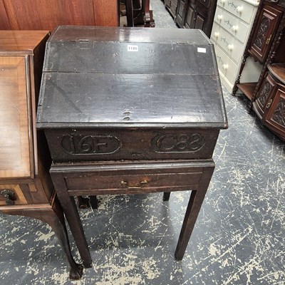 Lot 1185 - An oak slanted lidded bible box carved with...