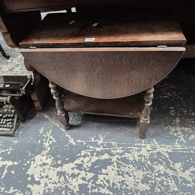 Lot 1201 - An oak oval drop flap coffee table with a tier...