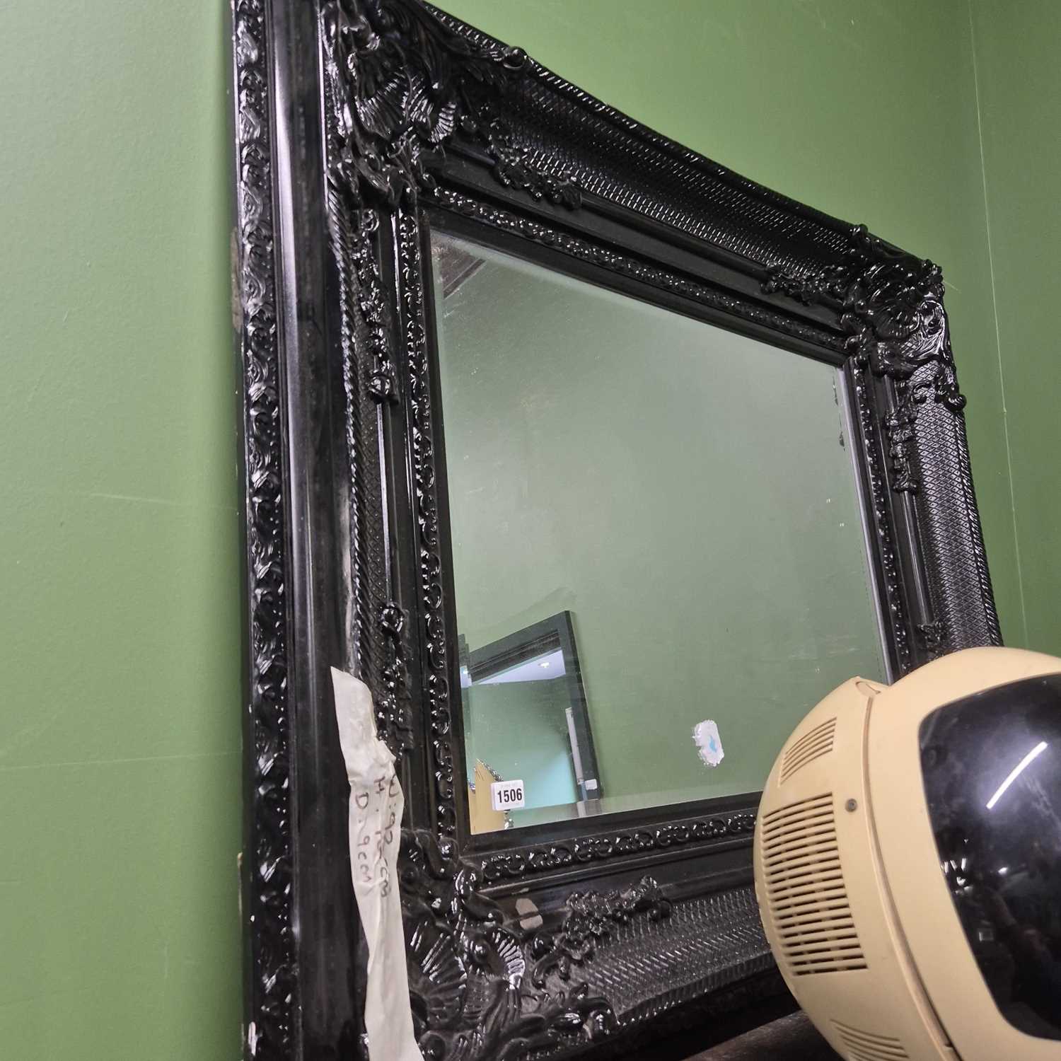 Lot 1506 - A large wall mirror with black frame