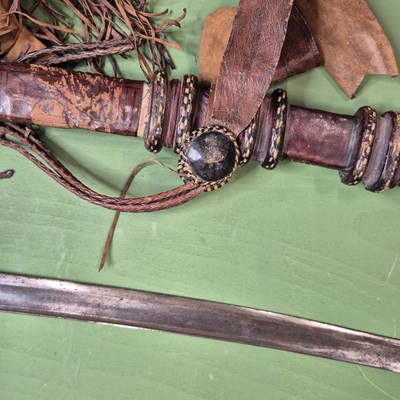 Lot 391 - An African single edged curved sword with a...