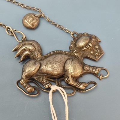 Lot 161 - A Chinese white metal Buddhist lion pendant on...