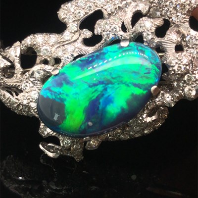 Lot 81 - A boulder opal and diamond pendant brooch....