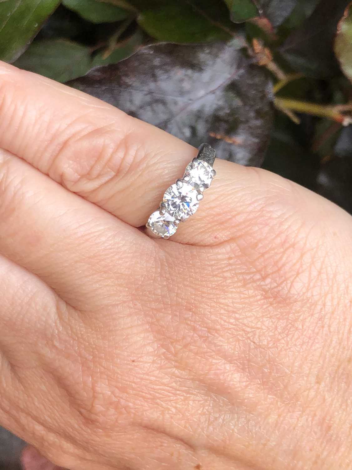 Lot 84 - A platinum hallmarked three-stone diamond,...