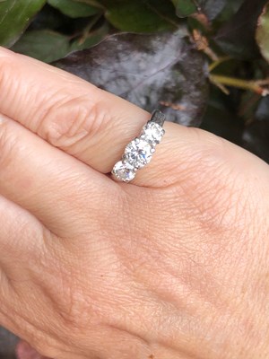 Lot 84 - A three-stone diamond, claw-set trilogy ring....