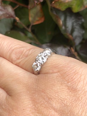 Lot 84 - A platinum hallmarked three-stone diamond,...