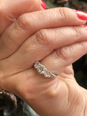 Lot 84 - A platinum hallmarked three-stone diamond,...
