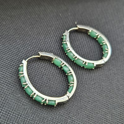 Lot 96 - A pair of emerald hinged hoop earrings....