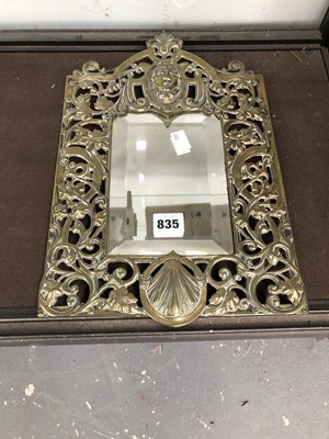 Lot 835 - A bevelled glass mirror in a brass pierced...