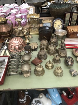 Lot 915 - A collection of brass bells, three clocks, a...