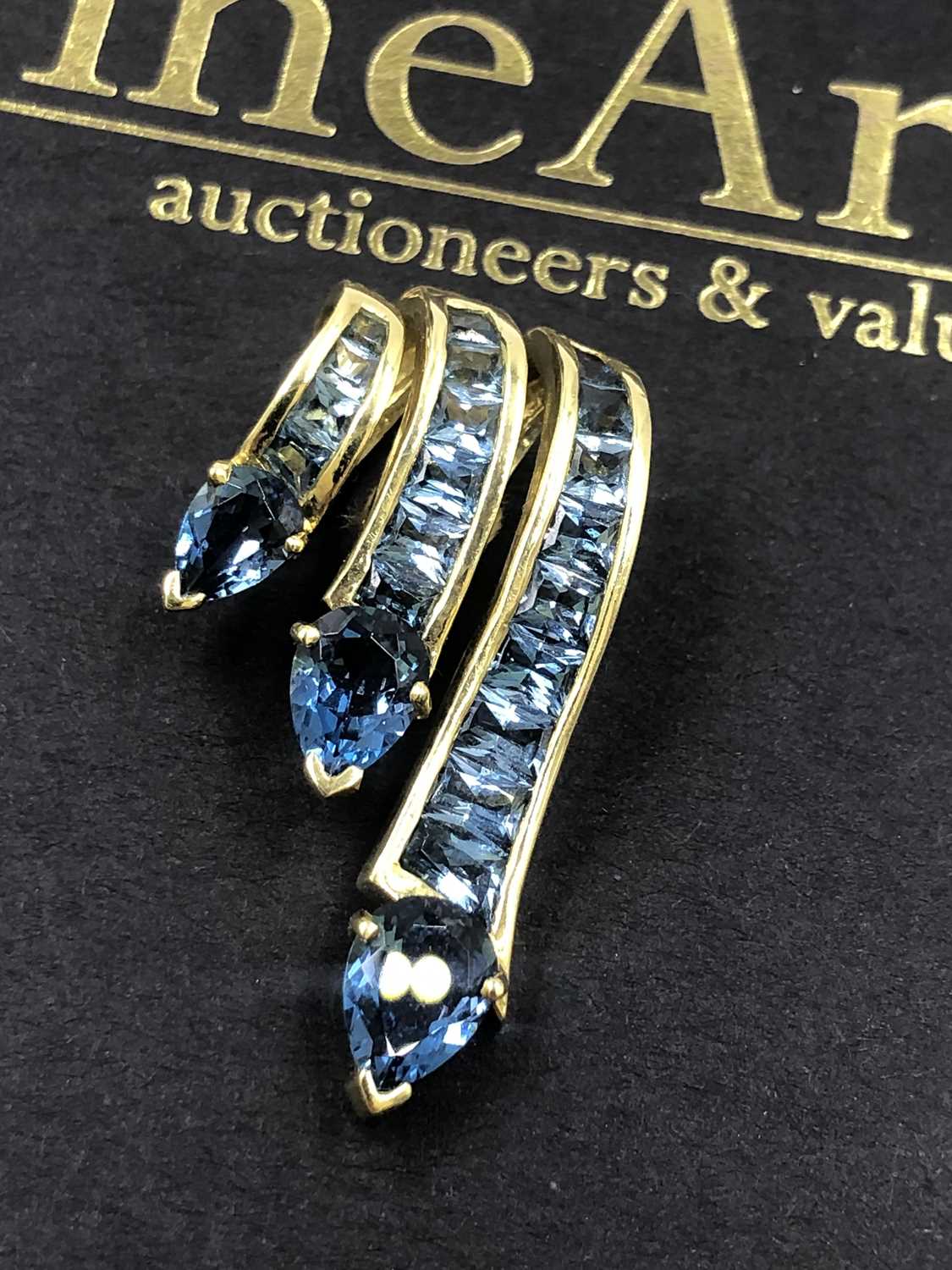 Lot 519 - A contemporary blue gemset triple cascade...