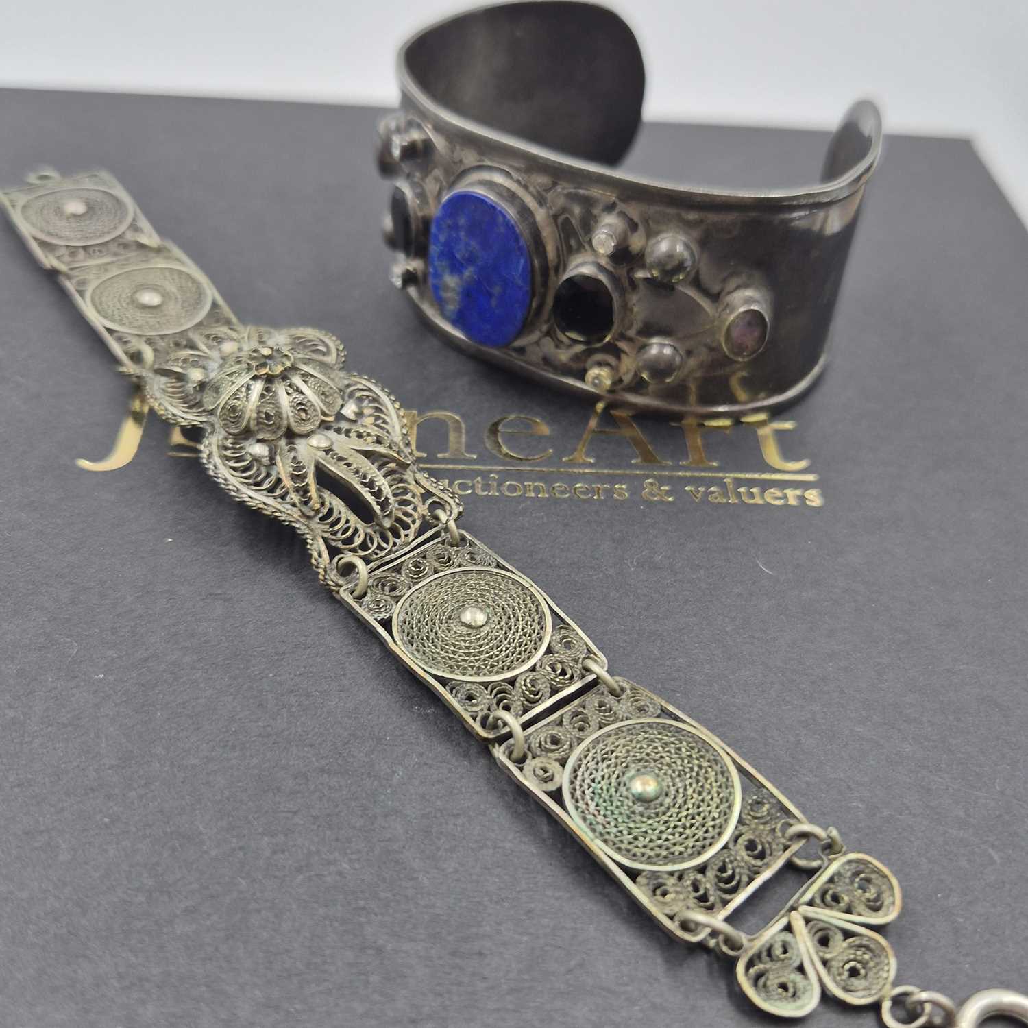 Lot 537 - A gemset wide cuff bangle and a filigree panel...