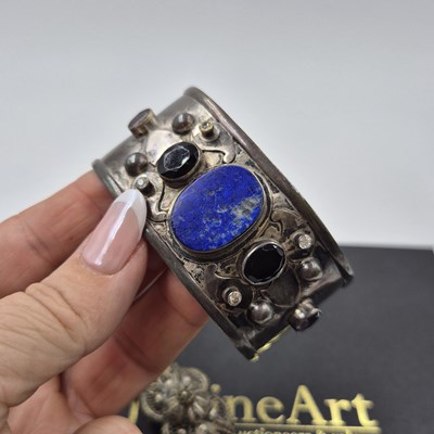 Lot 537 - A gemset wide cuff bangle and a filigree panel...