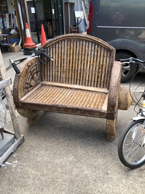 Lot 1333 - A rustic wagon wheel garden bench