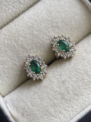 Lot 555 - A pair of oval emerald and round brilliant cut...