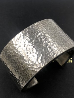 Lot 583 - A wide cuff bangle with a hammered finish....