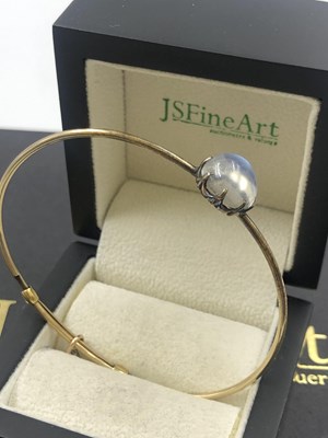Lot 557 - An antique moonstone cabochon bangle,...